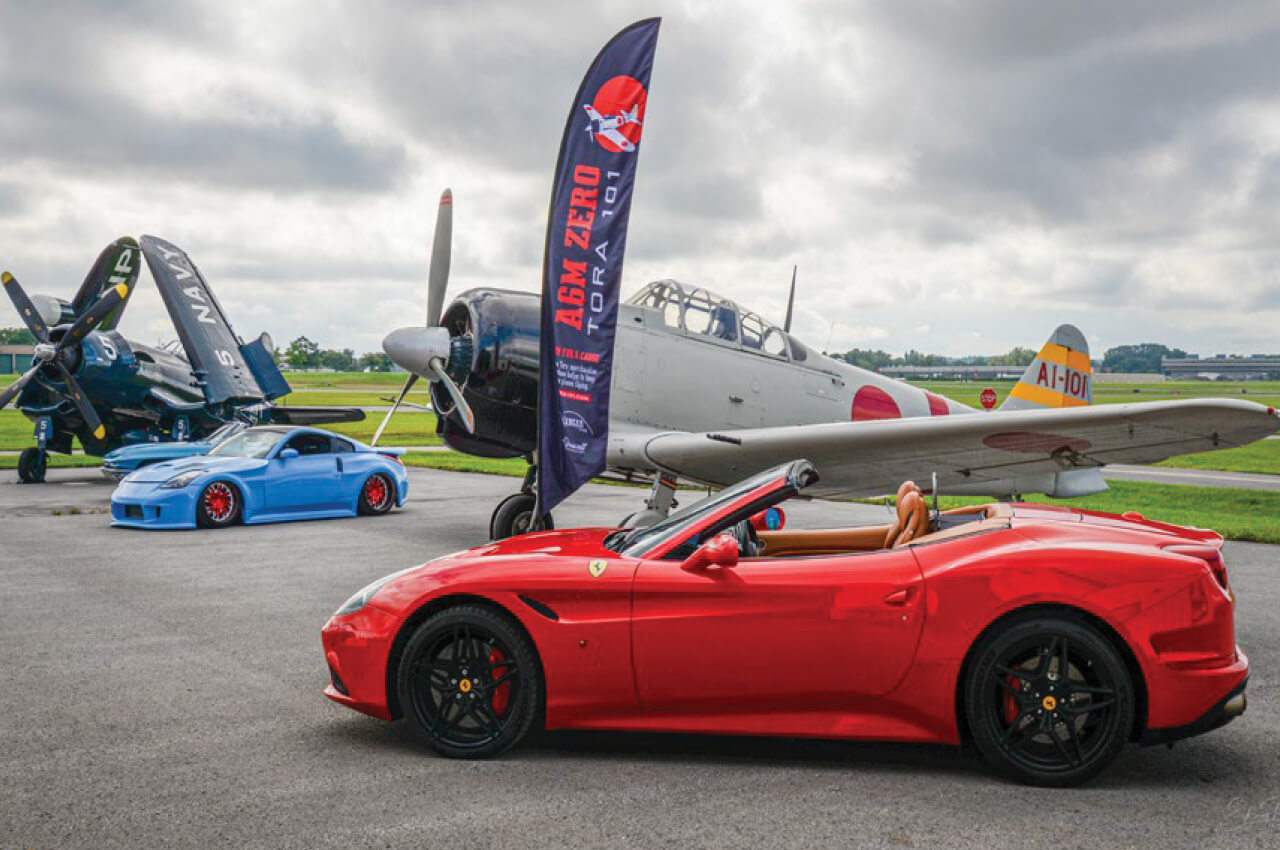 Red sports car in front of airplane
